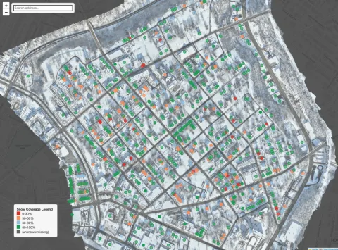 Neighborhood-scale map of Larimer over a winter drone orthomosaic, with one coloured dot per building showing its snow-retention bucket from red for 0 to 30 percent through green for 80 to 100 percent.